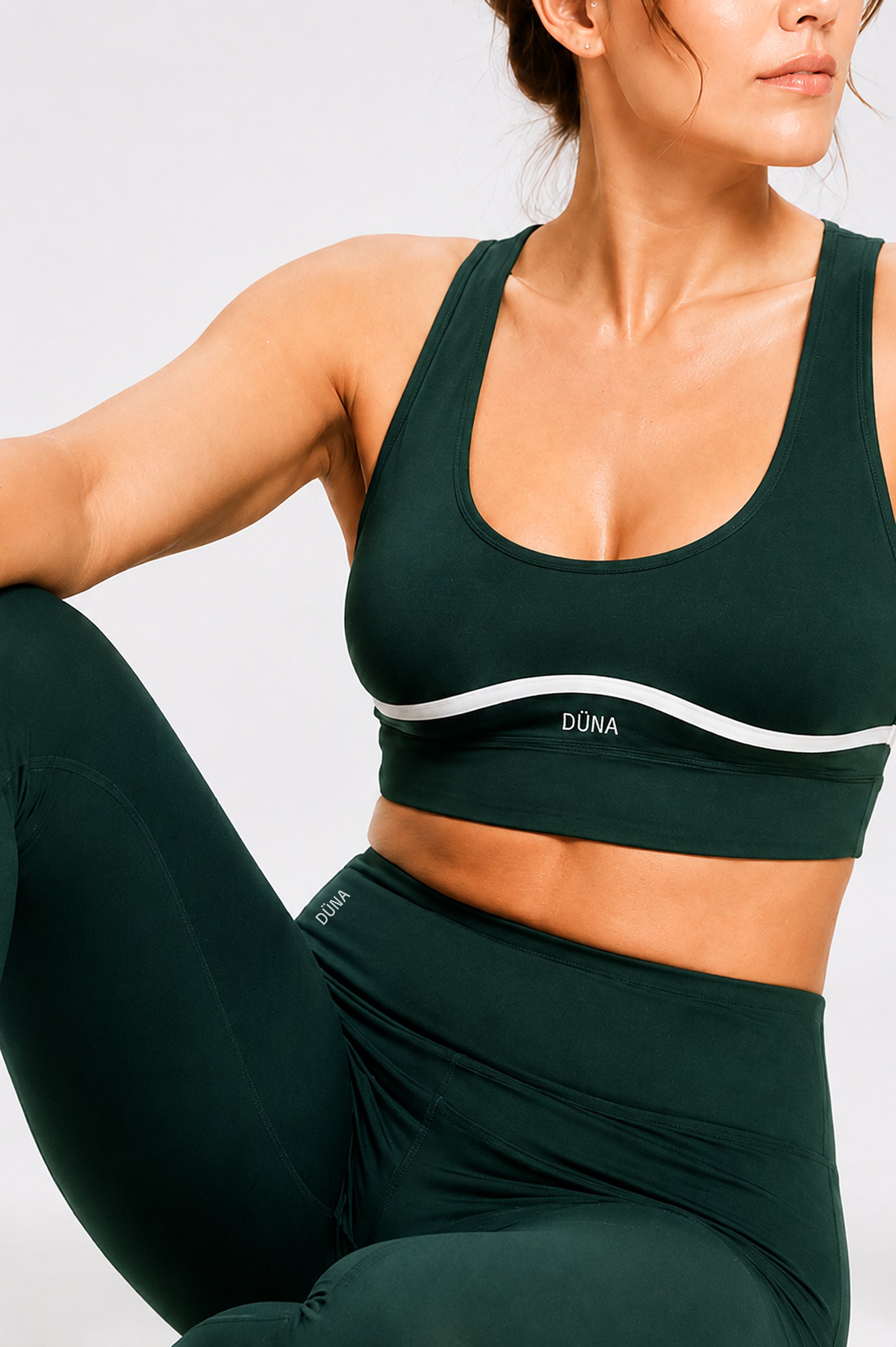 Brassière et legging DÜNA vert profond, détail vague signature